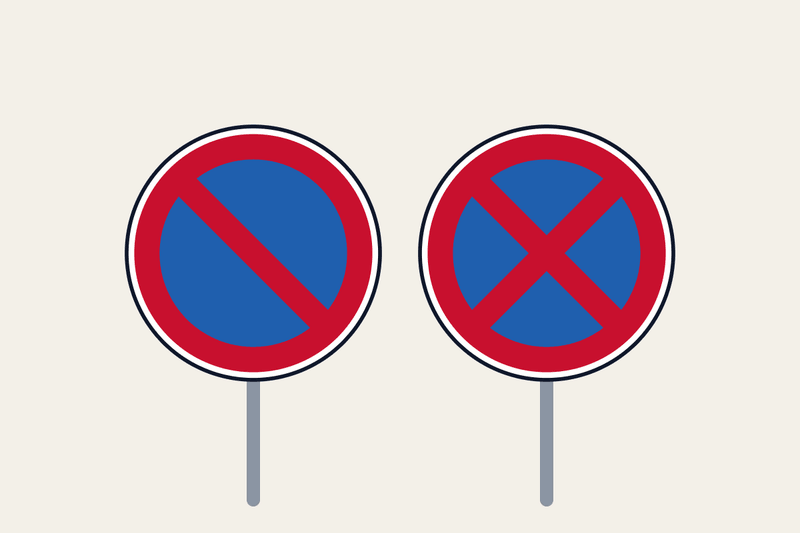 No-parking sign with one red slash beside the no-stopping sign with a red cross, both on blue